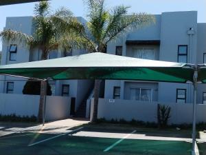 a large green umbrella in front of a building at Serengeti Self Catering Units in Bellville
