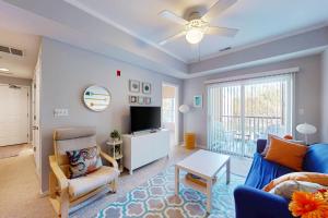 a living room with a blue couch and a tv at Captiva Sands at Eagles Landing --- 4500 Sand Piper Drive #4514 in Bald Eagle Village
