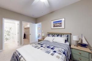 a bedroom with a bed with a blue and white comforter at Captiva Sands at Eagles Landing --- 4500 Sand Piper Drive #4514 in Bald Eagle Village