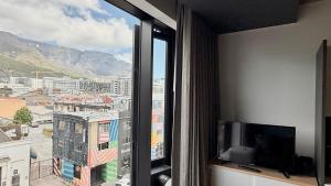 a room with a window with a view of a city at Stylish Cape Town Apartment - Table Mountain View in Cape Town