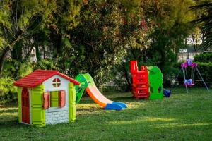 un groupe d'équipements de jeux pour enfants dans l'herbe dans l'établissement Feriendorf Le Tamerici Mobilehome Nuraghe für 6 Personen, à Marina di Cecina