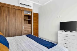 a bedroom with a bed and a tv on a dresser at Blue Wave Hideaway at Quinta Banderas Bay in Bucerías