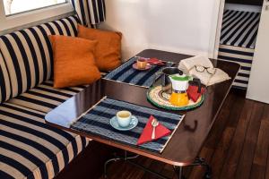 un salon avec une table basse et un canapé dans l'établissement Feriendorf Le Tamerici Mobilehome Asinara für 5 Personen, à Marina di Cecina