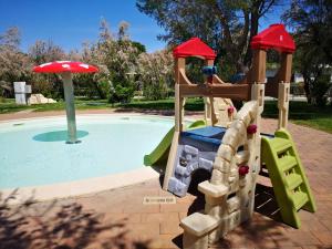 une aire de jeux avec un toboggan et une petite piscine dans l'établissement Feriendorf Le Tamerici Mobilehome Asinara für 5 Personen, à Marina di Cecina