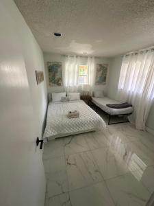 a white bedroom with a bed and a window at Beach and Down Town Hollywood in Hollywood