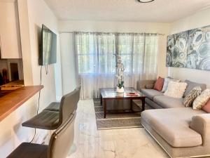 a living room with a couch and a table at Beach and Downtown Hollywood in Hollywood