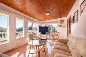 ein Wohnzimmer mit einer Couch und einem Tisch und Stühlen in der Unterkunft Villa en Son Gall Ciutadella in Ciutadella