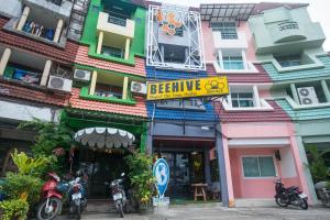 a building with motorcycles parked in front of it at Beehive Phuket Old Town Hostel in Phuket