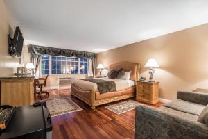 a bedroom with a bed and a couch and a window at Riverside Hotel, an Ascend Collection Hotel in West Chesterfield
