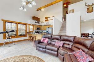 a living room with a leather couch and a camera at Woodland Chalet in Boyds Creek