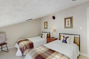 two beds in a room with white walls at The Glen C10 in Sugar Mountain