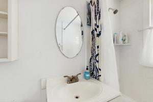 ein weißes Badezimmer mit Waschbecken und Spiegel in der Unterkunft The Kettle Cottage in Cotuit + 24 Fotos