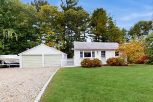 ein weißes Haus mit Garage im Hof in der Unterkunft The Kettle Cottage in Cotuit