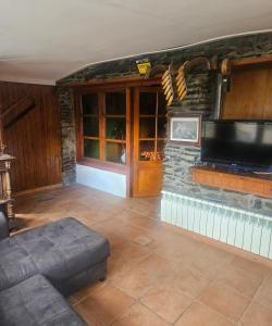 a living room with a tv on a stone wall at Spacious House in Canejan with Mountain View in Caneján