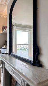 a mirror sitting on top of a fireplace at Battersea Boutique Apartments in Bangor