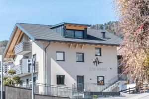 a white building with a sign on it at Aster Moments Apt Moritz in San Genesio Atesino