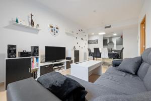 un soggiorno con un divano e una TV di Viudelta a Sant Jaume d'Enveja