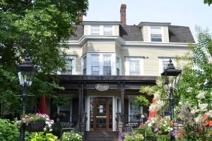 a white house with flowers in front of it at The Peacock Inn, an Ascend Collection Hotel in Princeton