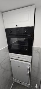 un horno blanco y negro en una cocina en Leaf & Loft, en Novi Sad