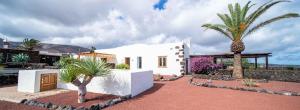 a white house with palm trees in front of it at Casa Margarita 2 in Mala