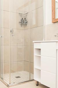a shower with a glass door in a bathroom at Peaceful Home In Richmond Hill in Gqeberha