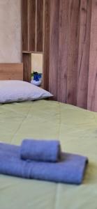 Una cama con una toalla azul encima. en Leaf & Loft, en Novi Sad
