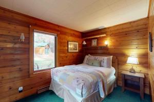 a bedroom with a bed in a room with wooden walls at Camp Farrell Cabin in Manitowish Waters