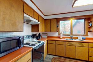 a kitchen with wooden cabinets and a stove top oven at Camp Farrell Cabin in Manitowish Waters