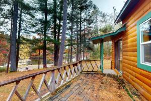 a porch of a wooden house with trees at Camp Farrell Cabin in Manitowish Waters