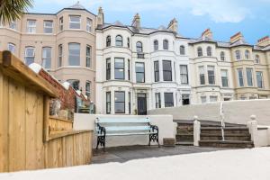 a blue bench in front of a large building at Battersea Boutique Apartments in Bangor