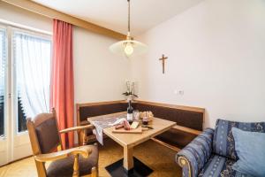 a living room with a table and a cross on the wall at Residence Pichler Apartment 3 in San Leonardo in Passiria +16 photos