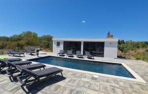 a swimming pool with lounge chairs and a house at Villa Jani by Villas Guide in Donja Jagodnja