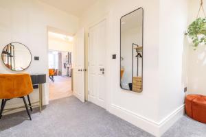 a hallway with a mirror and a table and chair at Battersea Boutique Apartments in Bangor +54 photos