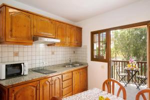 eine Küche mit Holzschränken, einem Tisch und einem Balkon in der Unterkunft Holiday Cottage Santa Lucía 1 in Santa Lucía + 21 Fotos