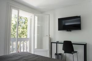 ソレントにあるMuta Houseの黒い椅子と壁掛けテレビ付きのベッドルーム1室