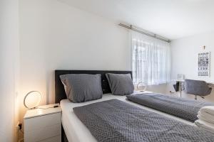 a white bedroom with a large bed with two pillows at Apartment Dußlingen in Dußlingen
