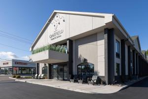 a store front of a building with benches in front at Oakfield Hotel & Suites, an Ascend Collection Hotel in Rochester