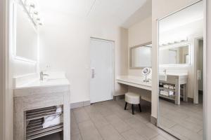 a bathroom with a sink and a desk and a mirror at Oakfield Hotel & Suites, an Ascend Collection Hotel in Rochester +25 photos