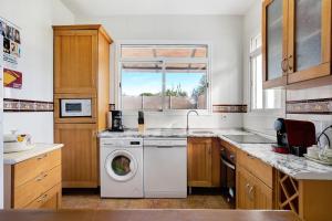 a kitchen with a washing machine and a window at Los Olivos in Barbate