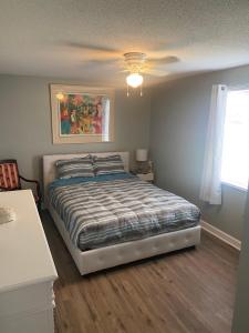 a bedroom with a bed and a ceiling fan at Historic 1BR Apt Kitchen Near VSU SGMC Down Town in Valdosta