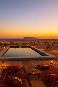Ein Swimmingpool mitten in der Wüste bei Sonnenuntergang in der Unterkunft Soléi Desert Retreat in siwa oasis