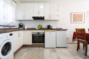 a kitchen with white cabinets and a washer and dryer at Superbly situated Vistamar in Mijas Costa