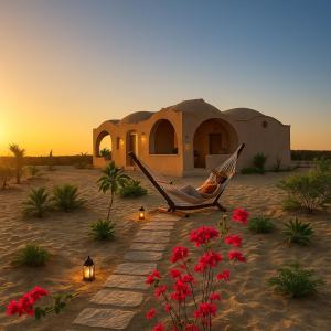a person sitting in a hammock in front of a house at Soléi Desert Retreat in siwa oasis