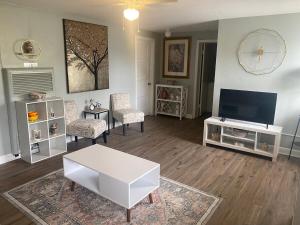a living room with a television and a white table at Historic 1BR Apt Kitchen Near VSU SGMC Down Town in Valdosta