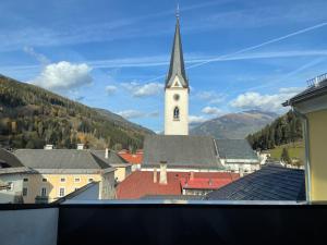 a church with a steeple and a clock tower at Gh Alte Post - Top 8 Kapitän in Gmünd in Kärnten