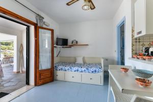 a bedroom with a bed and a table and a door at Villa Oda - Bilocale sul mare in Capoliveri +11 photos