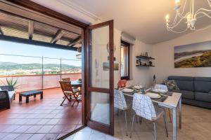 een eetkamer en woonkamer met een tafel en stoelen bij Attico il Mandorleto in Villasimius