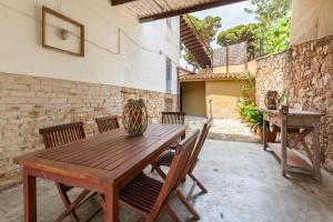 a wooden table and chairs on a patio at Masia Sant Miquel in Canet de Mar
