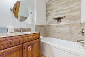 a bathroom with a tub and a sink and a tub and a mirror at Woodland Chalet in Boyds Creek +17 photos