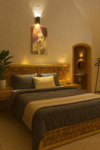 a bedroom with a large bed with a painting on the wall at Soléi Desert Retreat in siwa oasis